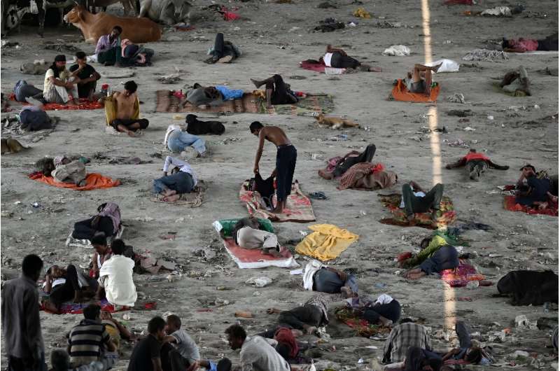 Homeless people take rest under a bridge to get respite from the heat on a hot summer afternoon in New Delhi