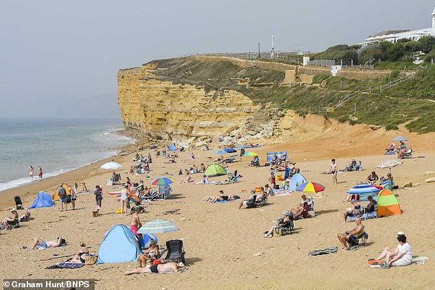 Heatwave Britain: Sun-seekers escape sweaty cities and pack out beaches as 32C temperatures scorch the country – with record heat set to last all week