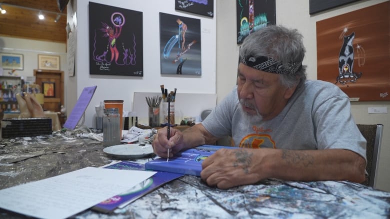 An artist works on a painting in his studio