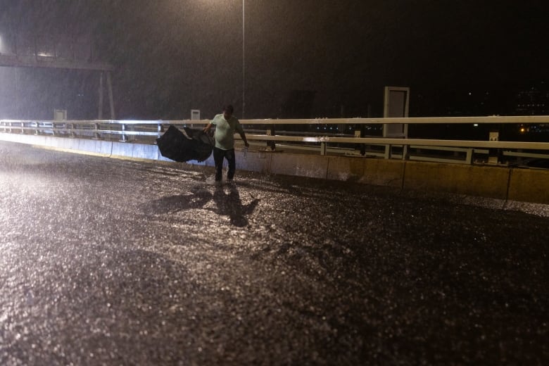 A pedestrian walks along a stretch of flooded roadway in Hong Kong.