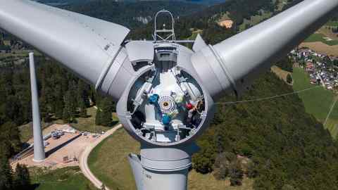 A man works on rotor engine of a wind turbine