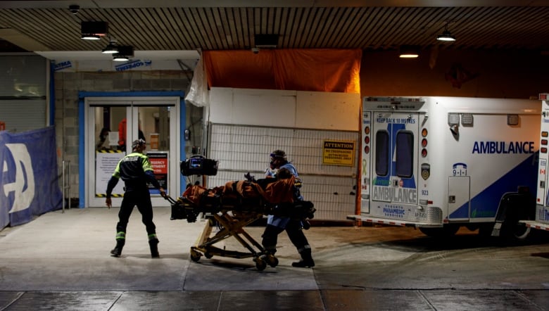 Ambulance paramedics unload a patient at the emergency department of St. Michael’s Hospital, in downtown Toronto, on Jan. 4, 2022. 