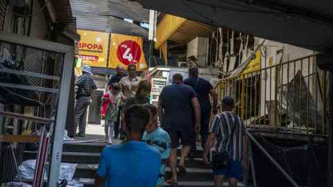 People pass through a damaged bus station in Dnipro, Ukraine