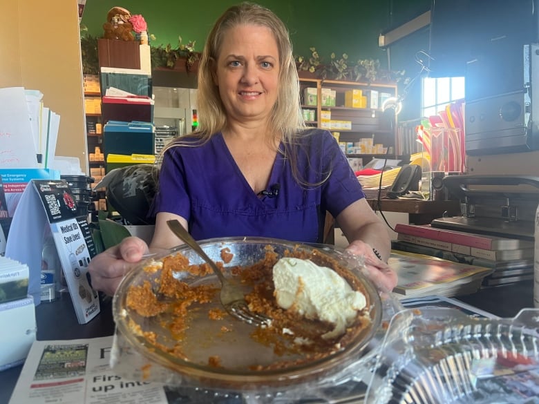 A woman holding a mostly eaten pie