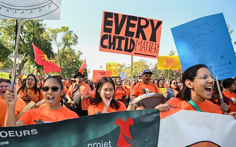 People march while holding signs and chanting.