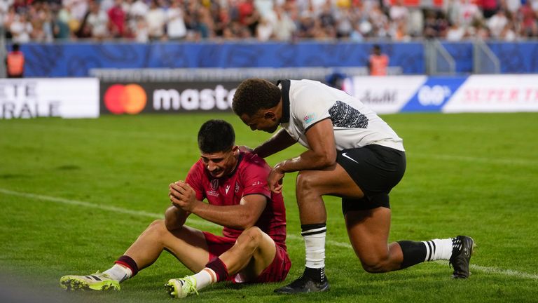 Fiji's Teti Tela, comforts Georgia's Luka Matkava after the final whistle