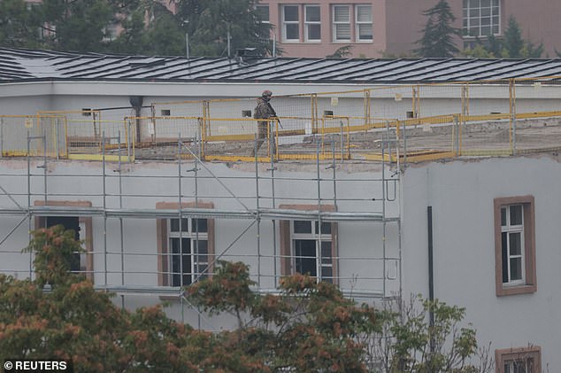 Armed soldiers were seen on the roofs of nearby buildings