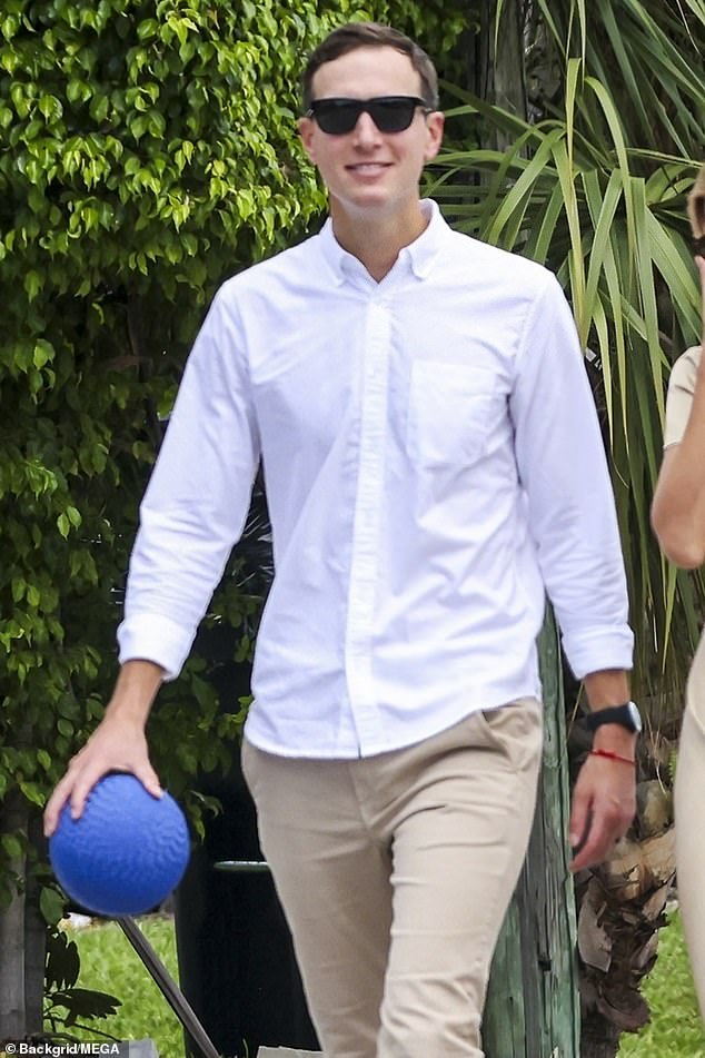 She is flanked by her husband, Jared Kushner, who wears a white shirt, beige trousers and trainers, while their three children ride scooters slightly ahead of them