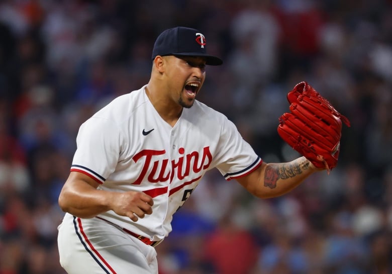 A men's pitcher celebrates on the field.