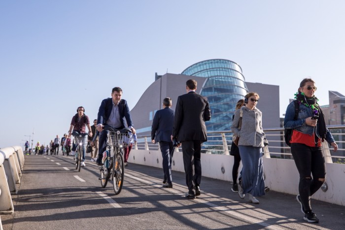 Commuters cross the River Liffey on the Samuel Beckett Bridge in Dublin