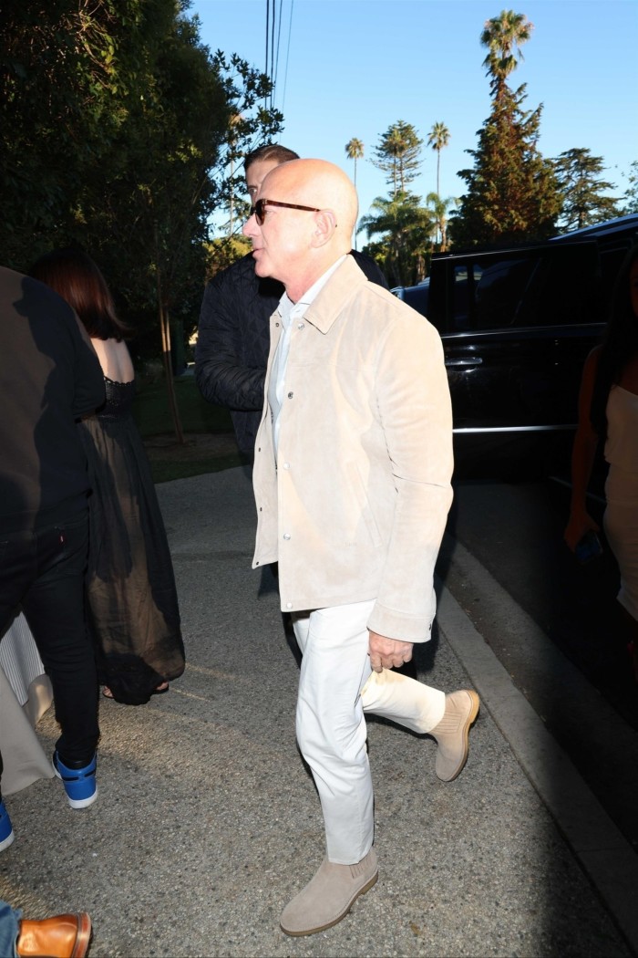 Jeff Bezos in cream coloured suede boots, cream jacket and white trousers