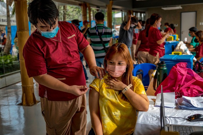 A woman receives a dose of Pfizer/BioNTech’s Covid vaccine in Manila, the Philippines