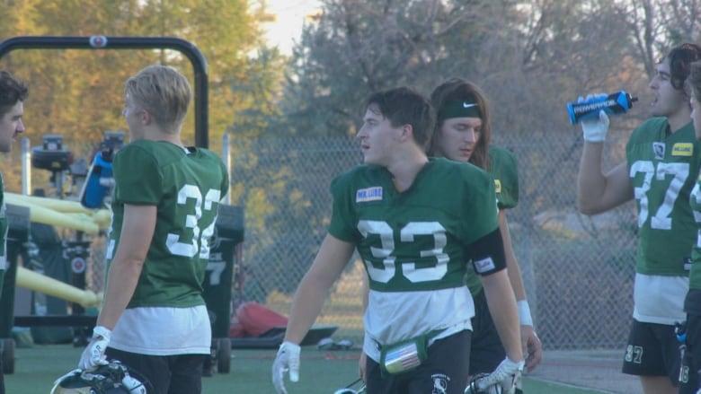 Football players in green kits walking around.