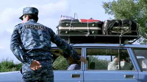 A police officer guides the driver of a car