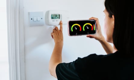 Close Up Of Woman Holding Smart Energy Meter In Living room Measuring Energy Efficiency