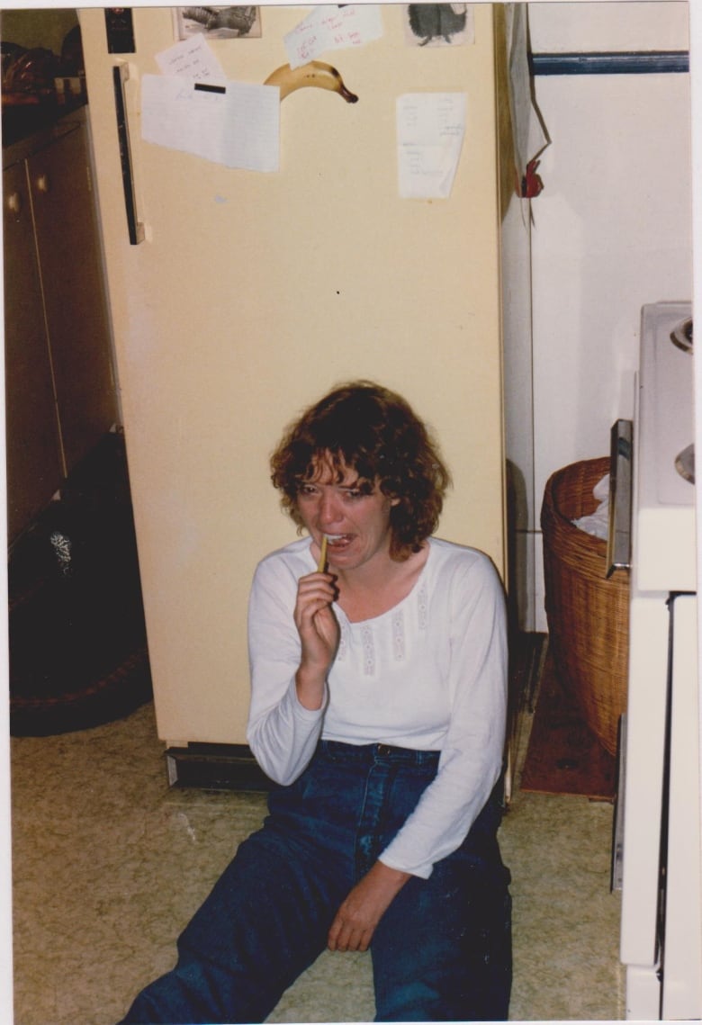 A crying woman sits on the floor.  