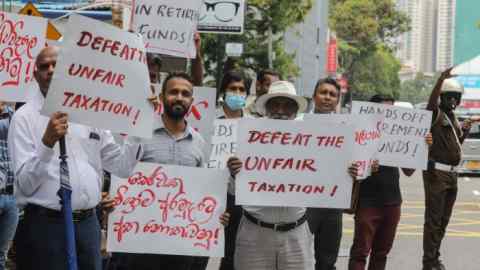 University lecturers hold up signs saying Stop the Unfair Taxation