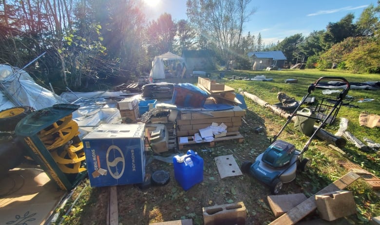 A pile of construction supplies lays spread out on grass. 