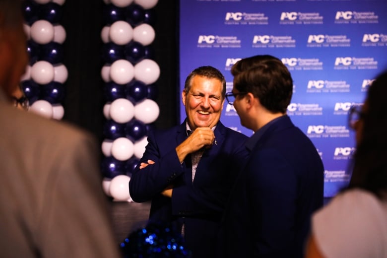 Politicians laugh and talk at a campaign event.