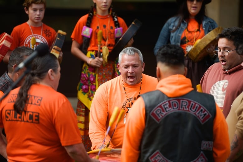 Men play a drum.