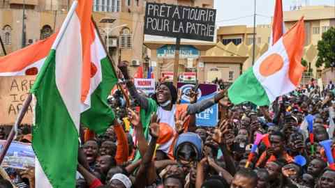 Supporters of Niger’s National Council for the Safeguard of the Homeland hold national flags as they gather in Niamey on August 20