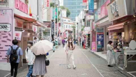 People walk down a colourful street in Tokyo