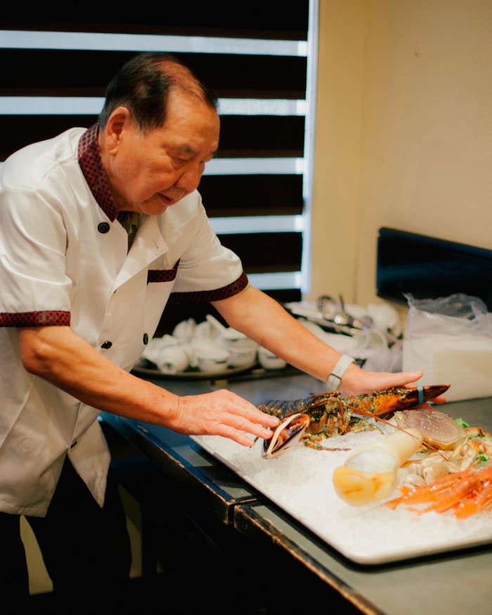 Chef David Li of Landmark with a lobster and seafood on a bed of ice 