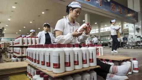 Employees arrange bottles of Moutai baijiu at the Kweichow Moutai factory