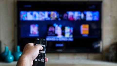 A remote control being pointed at a TV