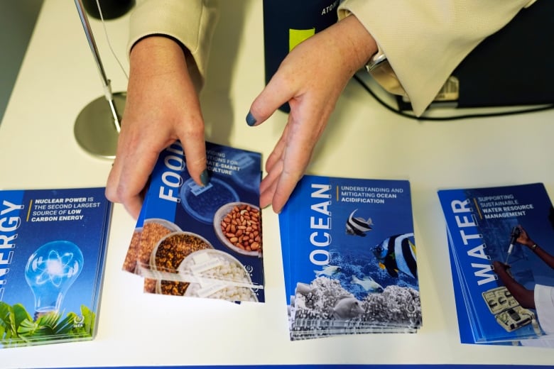 A person grabs a pamphlet that talks about food issues related to climate change.