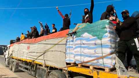 Hamas fighters ride on top of a humanitarian aid truck in Rafah, the Gaza Strip