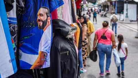 Nayib Bukele’s image is seen on a T-shirt hanging at a market in El Salvador. Few citizens worry that their president is bringing the legislature and judiciary to heel or that he is violating the constitution