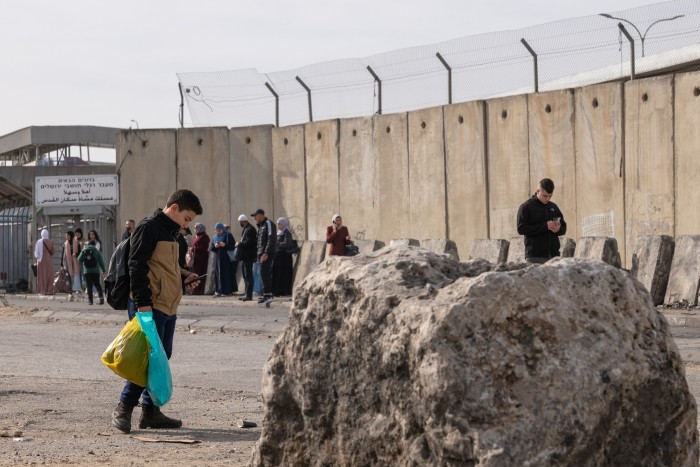 People wait to enter Israel at the Qalandia checkpoint outside Ramallah