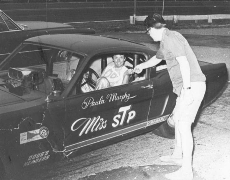 A woman sits in a car. 