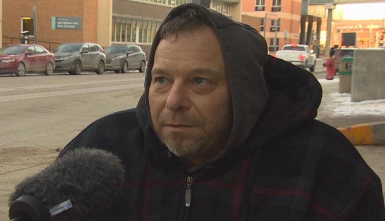 A man in a hoodie is pictured looking forward.