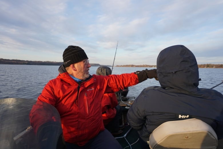 photo of a man on a boat pointing at something