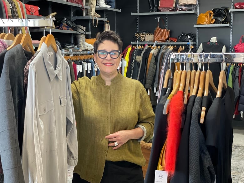 Ginette Robichaud with clothing racks in her store