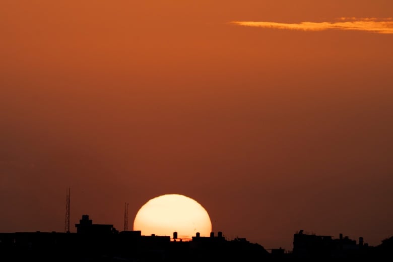 The sun is seen setting behind the Gaza Strip, as viewed from a vantage point in southern Israel, on Wednesday.