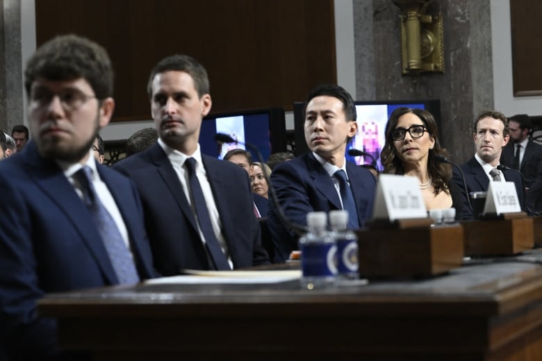 People are look to their right as they are seen seated at a table.