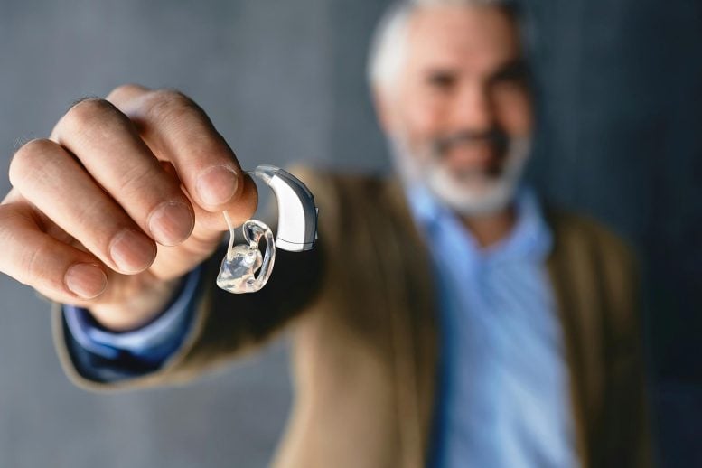 Man Holding Hearing Aid