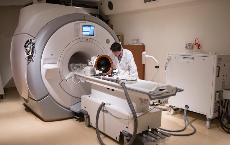 A member of a medical team prepares a MRI machine.