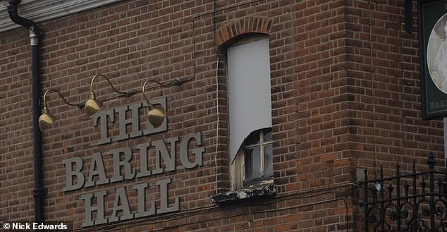 A gap appears in the boarded up windows of The Baring Hall pub on February 13