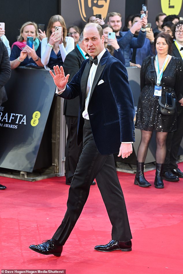 William offers a wave to crowds as he arrives for this year's BAFTAs ceremony. The Prince opted for a velour navy blue dinner jacket for the most glamorous night in the film calendar