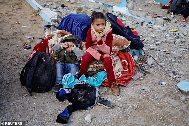 Palestinian children rest outside after arriving in Rafah following their evacuation from Nasser hospital in Khan Younis on February 15, 2024