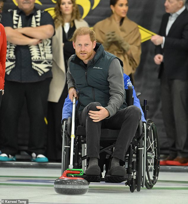 Prince Harry’s most fashionable fan! Glamorous Meghan Markle cheers on her grinning husband as he competes against Michael Buble in wheelchair curling – hours after opening up about King Charles’ cancer diagnosis and US citizenship in latest tell-all chat