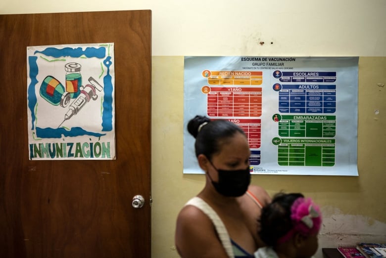 A mother and her daughter wait at a community health centre to complete their vaccination schedule, in Caracas, in 2022. 