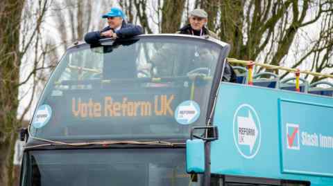 Reform UK deputy leader and Wellingborough candidate Ben Habib, left, on the party’s bus in Wellingborough, England