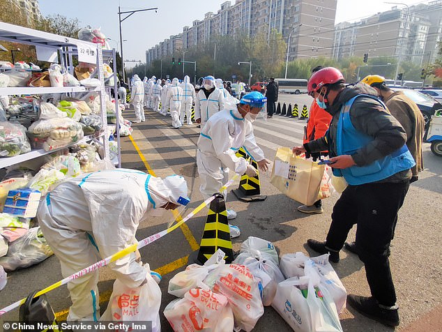 Workers arrange food supplies at the Tiantongyuan residential complex where residents are under lockdown to halt the spread of the Covid-19 coronavirus on November 3, 2021 in Beijing