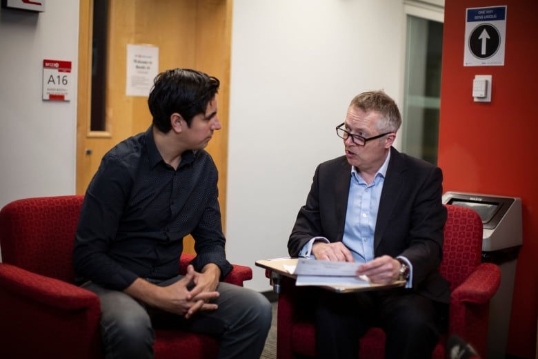 Forensic pathologist Matthew Orde in Vancouver reviews Kamilah Sword's coroner's report with CBC reporter Jon Hernandez on Friday March 1, 2023. 