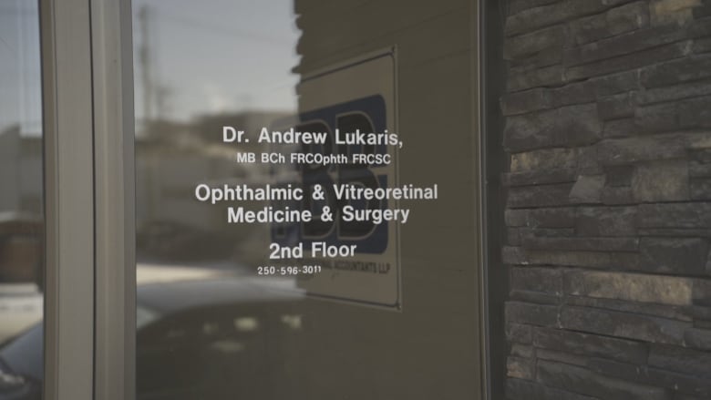 A screen door advertising services of a retinal specialist in a Prince George building. 